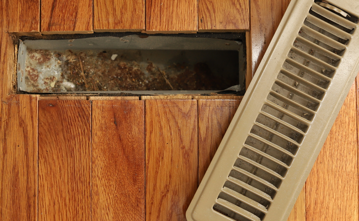 A opened heating/cooling vent register on the floor in a home home stock photo